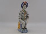 a figurine of a woman sitting on a stool