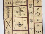 an old piece of cloth with designs on it sitting on a table