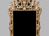 une image représentant un miroir doré sur fond noir, avec une horloge en arrière-plan