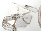 a silver plate with a broken heart on it and a necklace with a chain