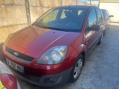 une photo d'une Ford Fiesta rouge garée sur un parking