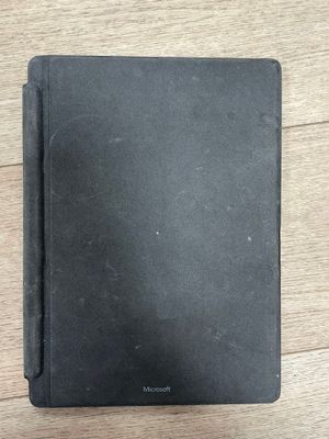 un cahier noir posé sur une table en bois