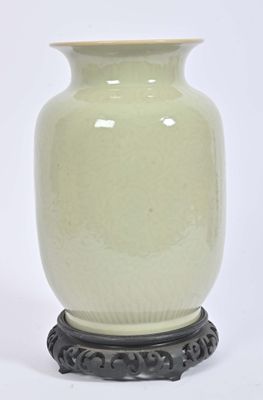 a white vase sitting on a black stand on a white background