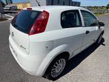 une petite voiture blanche garée dans un parking