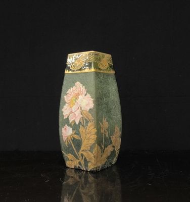 un vase vert avec des fleurs posé sur une table