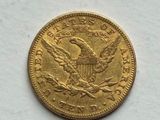 a close up of a gold coin on a white surface
