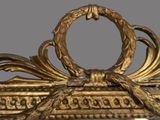 a mirror with a gold frame and a bird on it