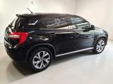 the back end of a black suv parked in a white room