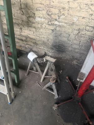 a red and white sign sitting on the ground next to a wall