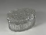 a clear glass box with a silver lid on a white surface