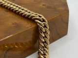 morceau de bois surmonté d'une chaîne en or