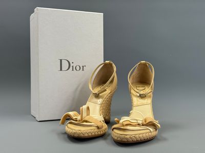 une paire de chaussures dorées avec une boîte en arrière-plan