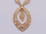 a close up of a gold necklace on a white surface