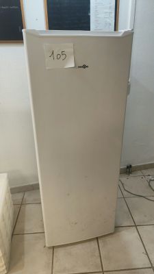 a white refrigerator sitting in a room with a chalkboard on the wall
