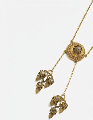gros plan d'un collier en or sur fond blanc