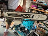 a man holding a chainsaw in a garage