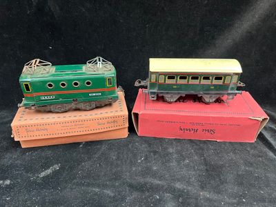 two toy trains sitting on top of boxes on a black surface