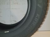 tire on the floor of a garage with a white wall in the background