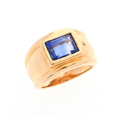 gros plan d'une bague en or avec une pierre bleue