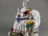 a porcelain figurine of a woman and child sitting on a chair
