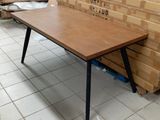 une table en bois aux pieds noirs posée sur un sol carrelé