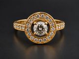 a yellow gold ring with a white diamond surrounded by diamonds