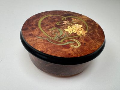 a small wooden box with a floral design on it