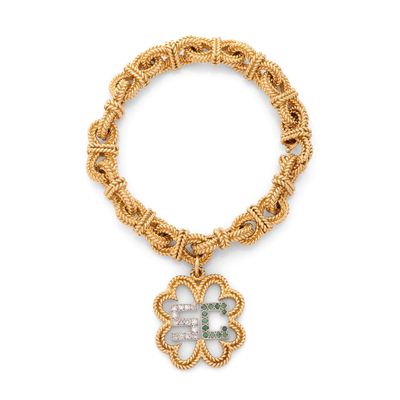 un bracelet en or orné d'un pendentif en forme de trèfle et d'une pierre verte
