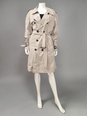 un mannequin vêtu d'un trench-coat beige et d'un haut noir