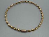 gros plan d'un bracelet en or sur une table