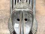 une image représentant un masque en métal accroché sur le mur