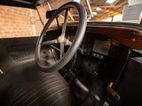 steering wheel and dashboard of an old car with a brick wall in the background