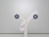 une paire de boucles d'oreilles en cristal bleu et blanc, posées sur un socle blanc