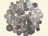 une pile de pièces d'argent posée sur une surface blanche