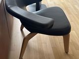 a chair and ottoman in a living room with wood flooring