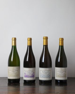 quatre bouteilles de vin sont alignées sur une table