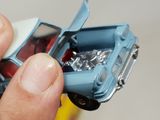 a person holding a small toy car in their hand