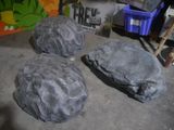 three fake rocks sitting on the floor in the garage