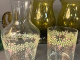 four vases and two glasses sitting on a table