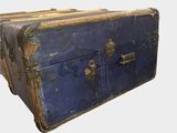an old blue suitcase sitting on top of a white table