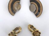two pairs of gold and black earrings on a white surface