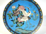 une assiette décorative ornée d'un oiseau et de fleurs