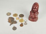 some coins and a bust of a woman sitting on a table