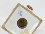 a small white plate with a brown button on it