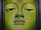 un tableau représentant un visage vert dans un cadre noir