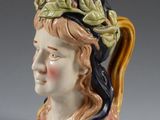 a ceramic figurine of a woman with a hat on her head