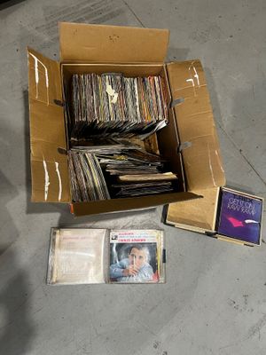a cardboard box full of cds and cds on the floor