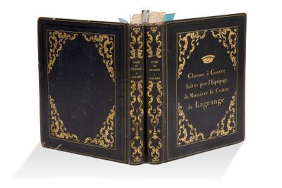 un vieux livre noir orné de dorures, dont la couverture est également rehaussée de dorures