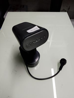 un petit objet noir posé sur une table, auquel est attaché un cordon