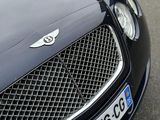 the front of a black bentley car parked on the side of the road